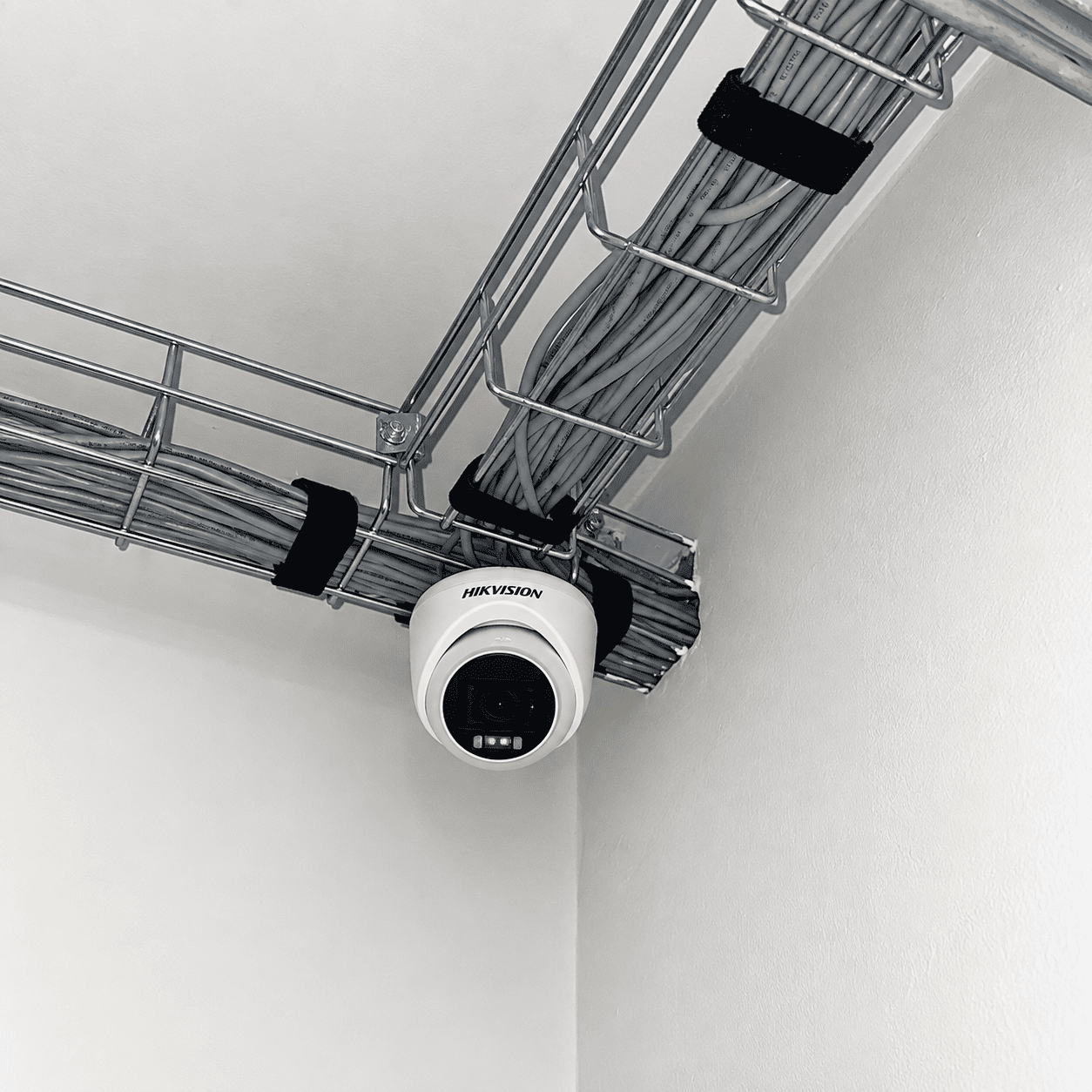 Cámara de seguridad instalada junto a una bandeja de cableado en Renova.