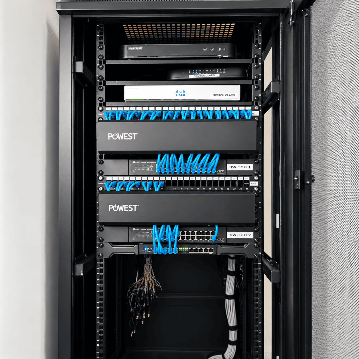 Rack de Renova con switches, paneles de conexión y cables de red azules organizados.