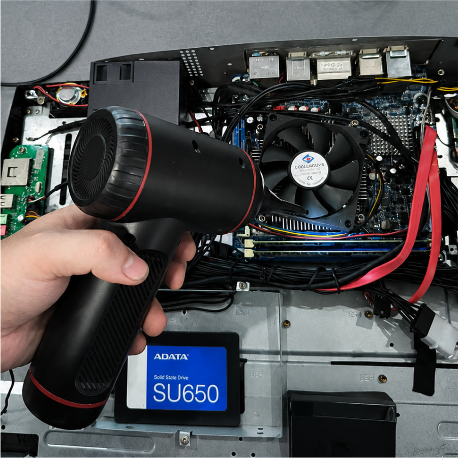 Limpieza interna de un computador de escritorio con un soplador durante su mantenimiento técnico.
