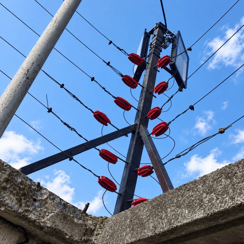 Detalle de los alambres y aisladores rojos de la cerca eléctrica de Callejas del Este.